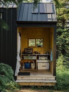 an outhouse in the woods with lots of storage and items inside it, including pots and pans