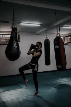 a woman is practicing boxing in a gym