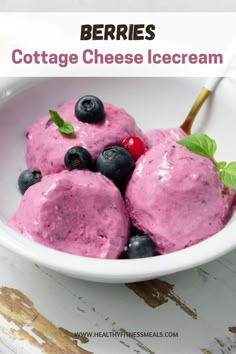 three scoops of cottage cheese ice cream in a white bowl with blueberries and raspberries