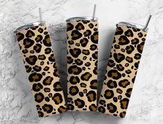 three leopard print tumblers sitting on top of a white marble counter next to each other