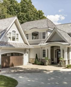 a large white house with two garages on the front and one car door open