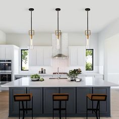 a large kitchen with an island and three stools