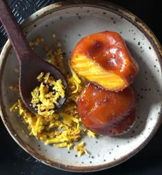 two donuts and scrambled eggs in a bowl with a spoon on the side,