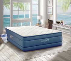 an inflatable mattress is sitting on the floor next to a window overlooking the ocean