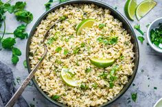 mexican rice with limes and cilantro in a skillet on a table