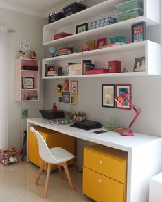 a white desk topped with yellow drawers next to a shelf filled with books and toys