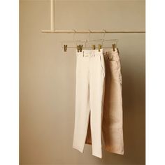 two pairs of pants hanging on a clothes rack