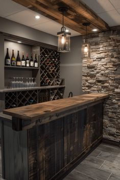 a home bar with wine bottles on the wall and lights hanging from the ceiling above it