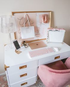 a white desk topped with a pink chair next to a computer