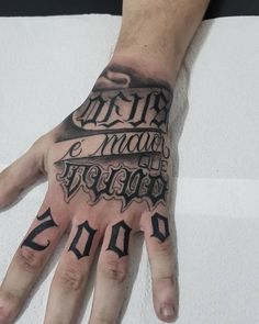 a man's hand with tattoos on it and the words written in black ink