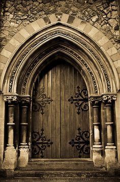 an old church door with ornate iron work on the front and side doors, in sepia