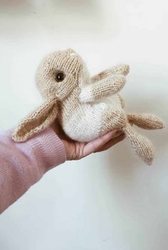 a person holding a knitted bunny in their hand with the text knitting body bunny written below it