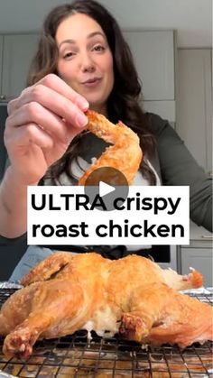 a woman holding up a piece of chicken on top of a metal rack with the words ultra crispy roast chicken