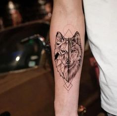 a man's arm with a tattoo on it that has a wolf in the middle