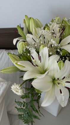 a bouquet of white flowers sitting on top of a bed