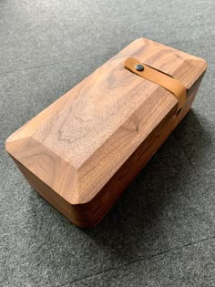 a wooden cutting board sitting on top of a gray floor next to a knife holder