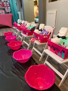 there are many chairs with pink bowls on the table in front of them and one is empty