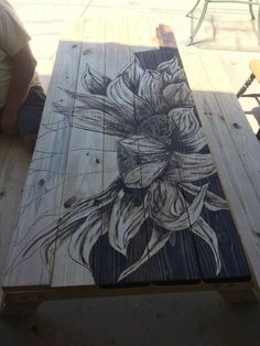 a table made out of pallet wood with flowers painted on it