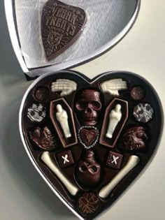 a heart shaped box filled with assorted chocolates in the shape of a man's face