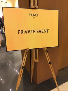 a private event sign on a tripod in front of a brown wall and floor