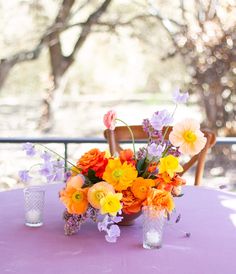 an arrangement of flowers on a purple table