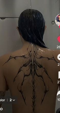 the back of a woman's body is covered in black paint