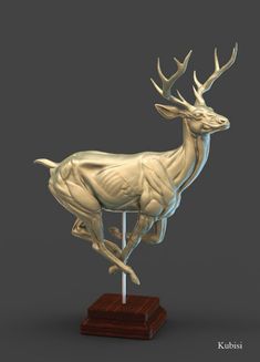 a gold statue of a deer on a wooden base