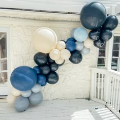 a bunch of balloons that are on the side of a building with white and blue