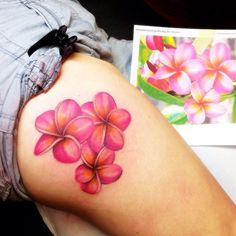 a woman's leg with pink flowers on it and a card in the background