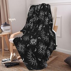 a black and white blanket sitting on top of a chair next to a wooden table