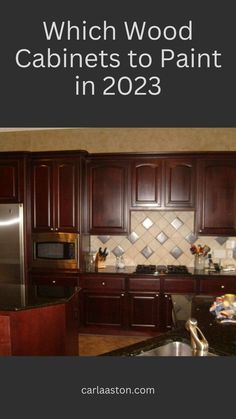 a kitchen with dark wood cabinets and granite counter tops in the center is a stainless steel refrigerator