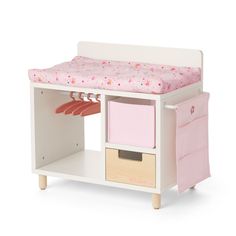 a toy bed with drawers and a pink blanket on it's top shelf next to a white dresser