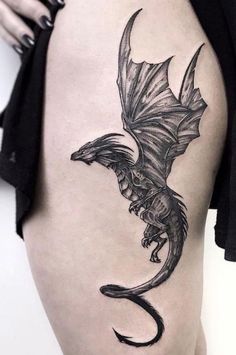 a woman's thigh with a dragon tattoo on it