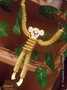 there is a monkey made out of spirals on the tree branch with green leaves