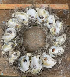 a wreath made out of seashells sitting on top of a wooden table