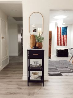 a living room with an american flag on the wall and a black table in front of it