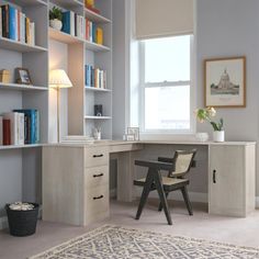 a room with a desk, bookshelf and chair in it that has a rug on the floor