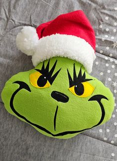 the grin face pillow is wearing a santa hat