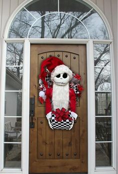 a front door decorated for christmas with a santa clause hat and checkerboard wreath