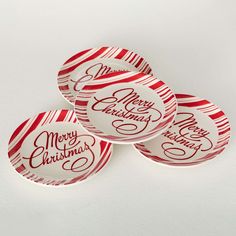 three red and white plates with merry christmas lettering on them, sitting next to each other