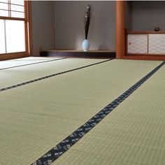 an empty room with tatami mats and vases on the floor in front of it