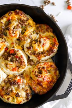 an iron skillet filled with mini pizzas on top of a white tablecloth