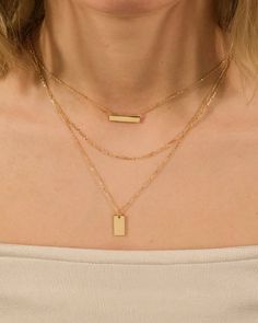 The layered look has never been so sleek or versatile! This triple layered bar necklace is perfect for anyone who wants to add a little shine to her look. Features a vertical and a horizontal smooth bar. Available in gold and silver tones. Materials: 14K gold or rhodium plated brass Features: Measures 14-20" with 2" extender, 0.75" bar, 0.5" tag pendant, Lead & Nickel free, lobster clasp Layer Bars, Silver Bar Necklace, Layered Look, Bar Necklace, Gold And Silver, Rhodium Plated, Lobster Clasp, Silver Tone, Sleek