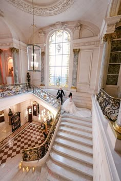 the bride and groom are walking down the stairs