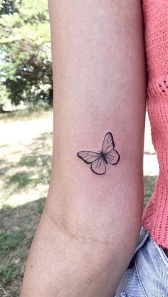 a woman's arm with a small tattoo of a butterfly on the back of her left arm