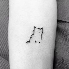 a small cat tattoo on the arm