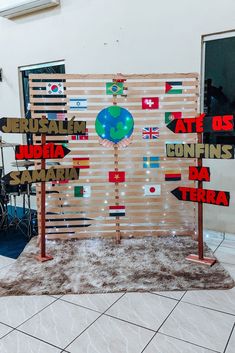 a group of wooden signs with flags on them in front of a wall that reads