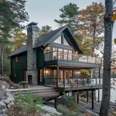 a house that is sitting on the side of a hill next to some rocks and trees