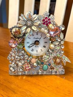 a clock that is sitting on top of a table with pearls and other things around it