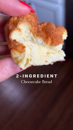 a hand holding a half eaten doughnut with the words 2 ingredient cheesecake bread